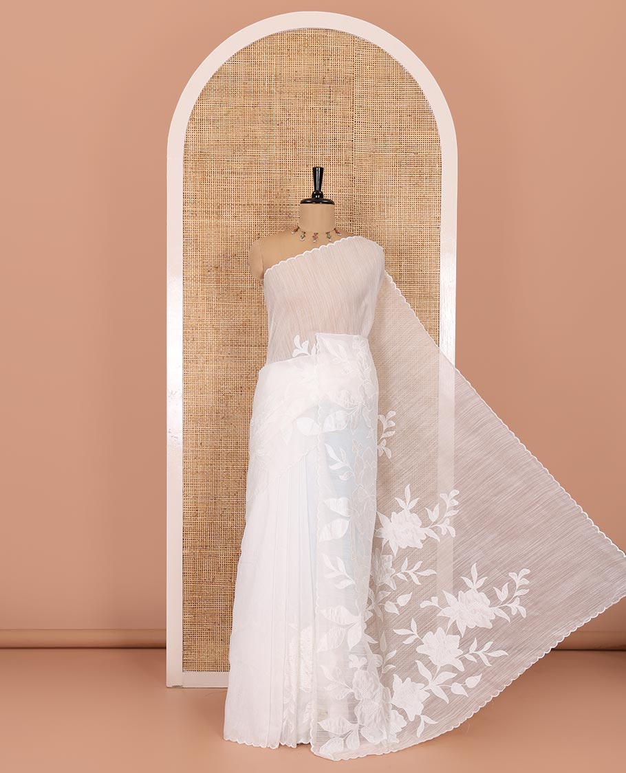 White floral motifs applique embroidered linen saree, scallop border, floral motifs embroidered pallu, and a plain blouse