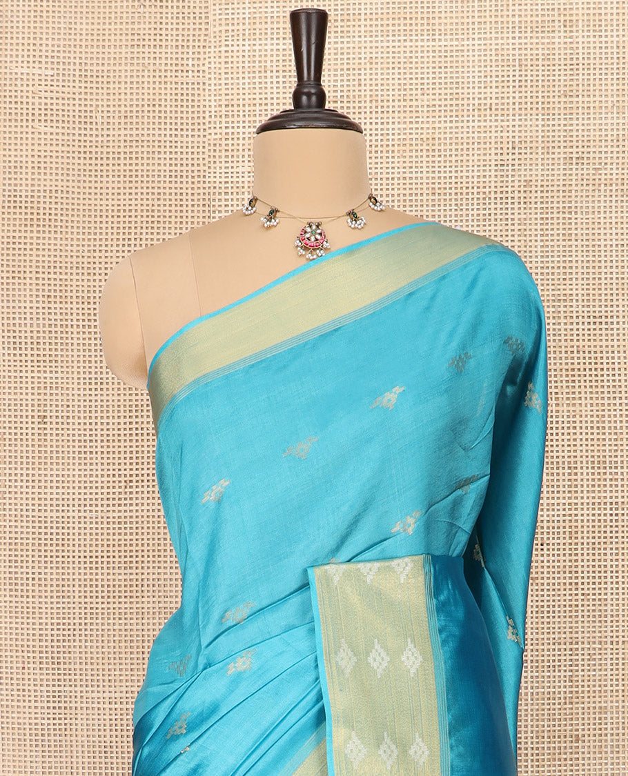 Blue Banana Pith Saree Elegantly Framed with Zari Buttas, Artfully Detailed Border with Zari Designs, Gleaming Zari Stripes Woven Pallu, and Paired with a Matching Plain Blouse