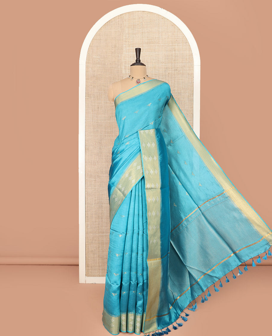 Blue Banana Pith Saree Elegantly Framed with Zari Buttas, Artfully Detailed Border with Zari Designs, Gleaming Zari Stripes Woven Pallu, and Paired with a Matching Plain Blouse