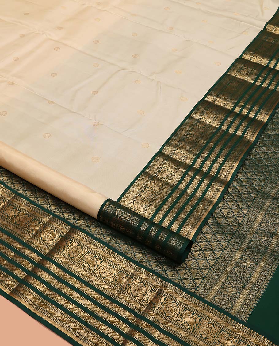 Cream Vasundhara Silk Saree, Enthralled with Zari Buttas All Over Its Body, Complemented by a Contrast Border of Muthu, Diamond, Kuthirai, Chakram, and Diamond Designs, Grand Pallu, and Paired with a Contrast Blouse