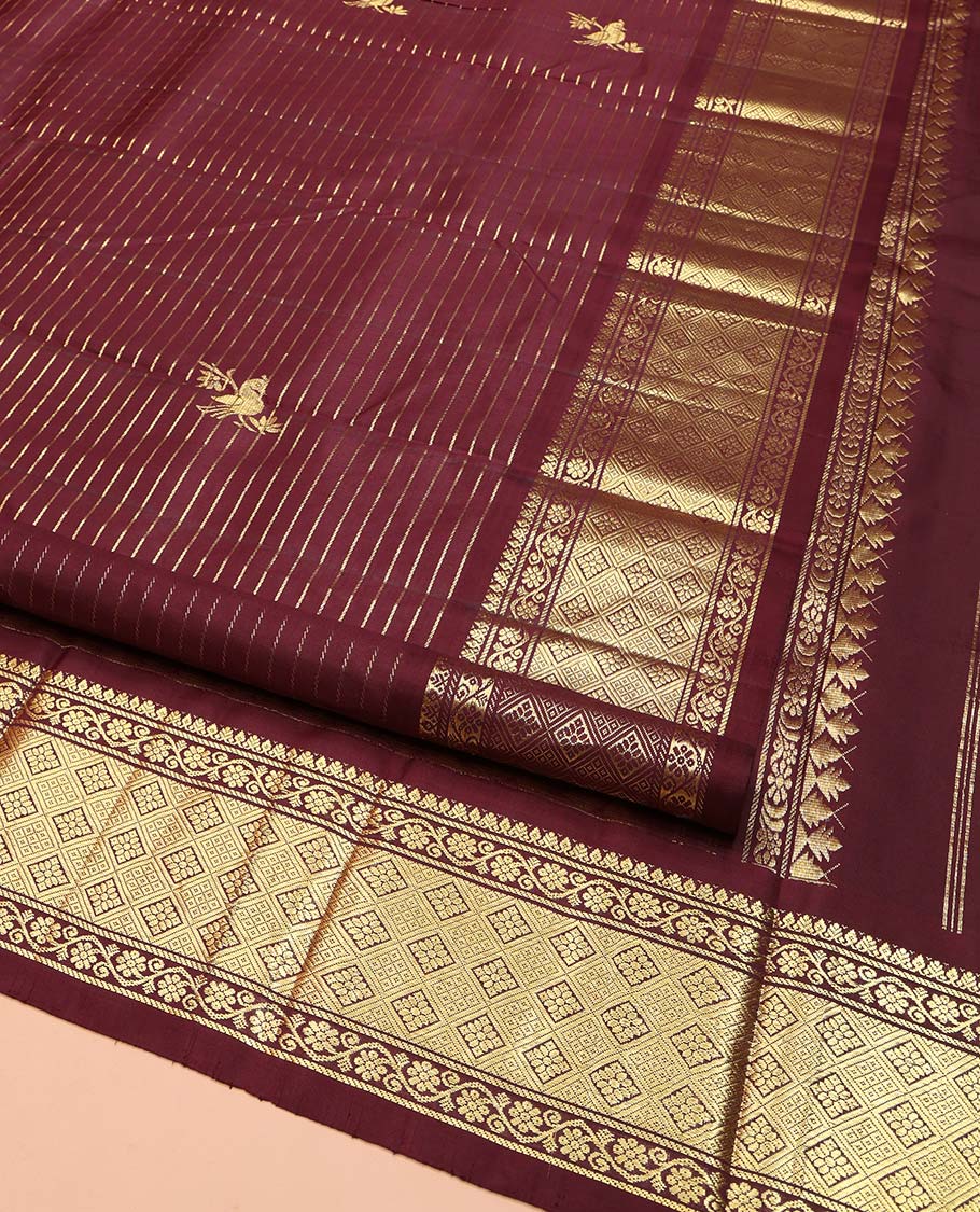 Maroon Kanchipuram Silk Saree, Gleamed Up with Zari Stripes and Bird Buttas on Its Body, Highlighted by a One-Sided Border of Kodi Visiry, and Jaal Designs, Pallu of Geometric Designs, and Comes Without a Blouse