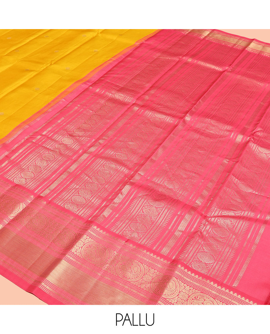 Mango Yellow Vasundhara Silk Saree, Subtly Sparkled with Sparse Stripes and Zari Buttas, Complemented by a Contrast Border of Thilakam, Banaras, Muthu, and Round Mayil Designs, Pallu Steeped with Traditional Designs, and Paired with a Contrast Blouse