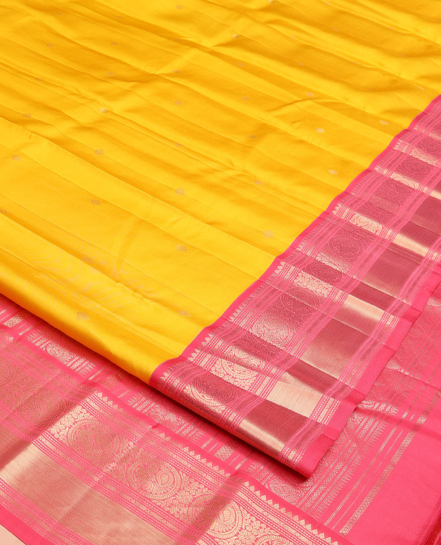 Mango Yellow Vasundhara Silk Saree, Subtly Sparkled with Sparse Stripes and Zari Buttas, Complemented by a Contrast Border of Thilakam, Banaras, Muthu, and Round Mayil Designs, Pallu Steeped with Traditional Designs, and Paired with a Contrast Blouse