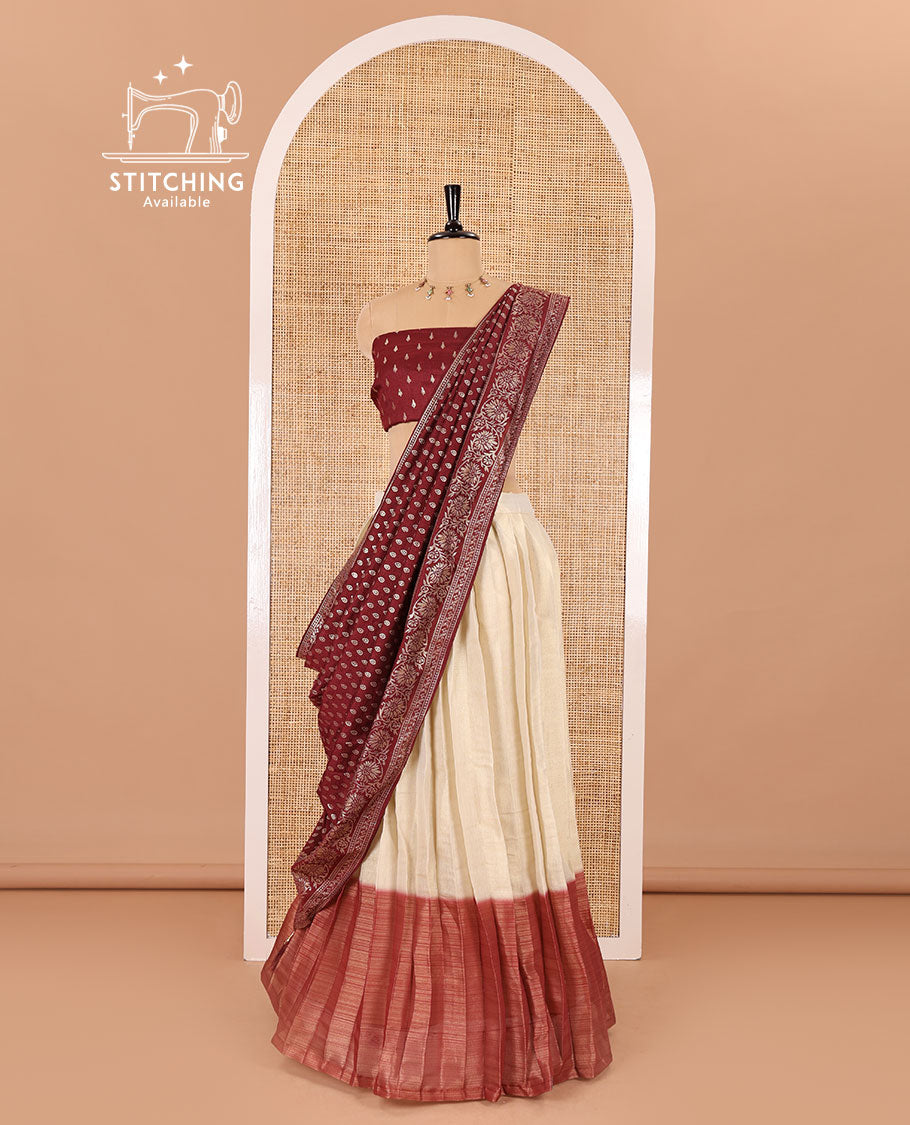 Cream-maroon Vichitra half-saree, plain and contrast bordered skirt, contrast leaf buttas blouse, dhavani of buttas and floral creeper designs