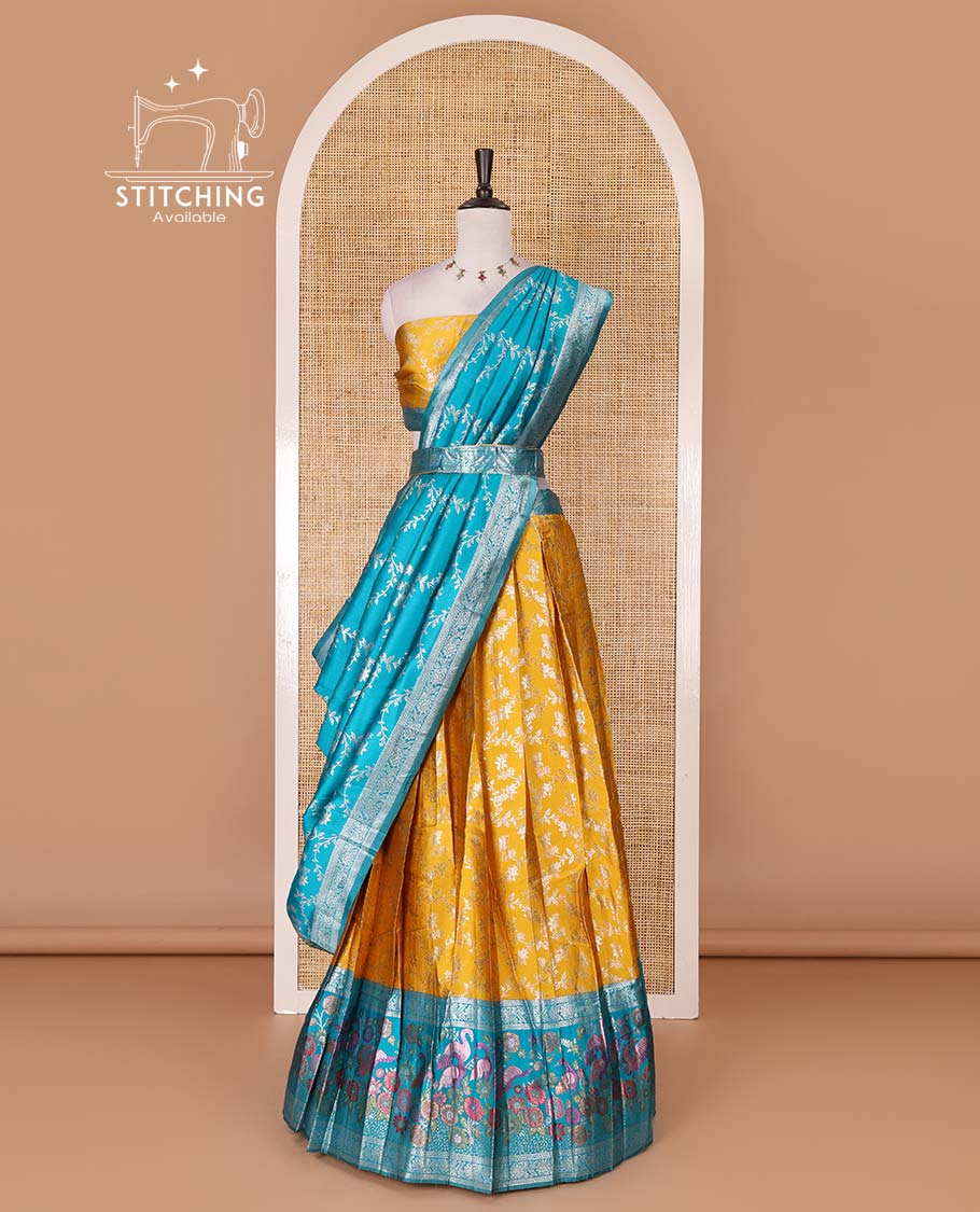 Haldi yellow taffeta silk half saree, floral jaal jacquard skirt, contrast green zari meenakari style bird border, matching blouse, and floral jaal dhavani