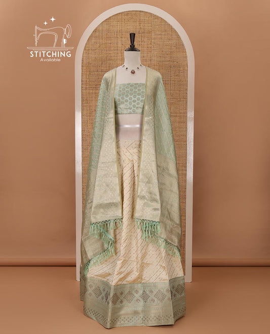 Cream semi-banaras material chudidar,leheriya zari skirt,contrast pista green zari & swarovski stonework border,jacquard blouse & zari weave dhavani