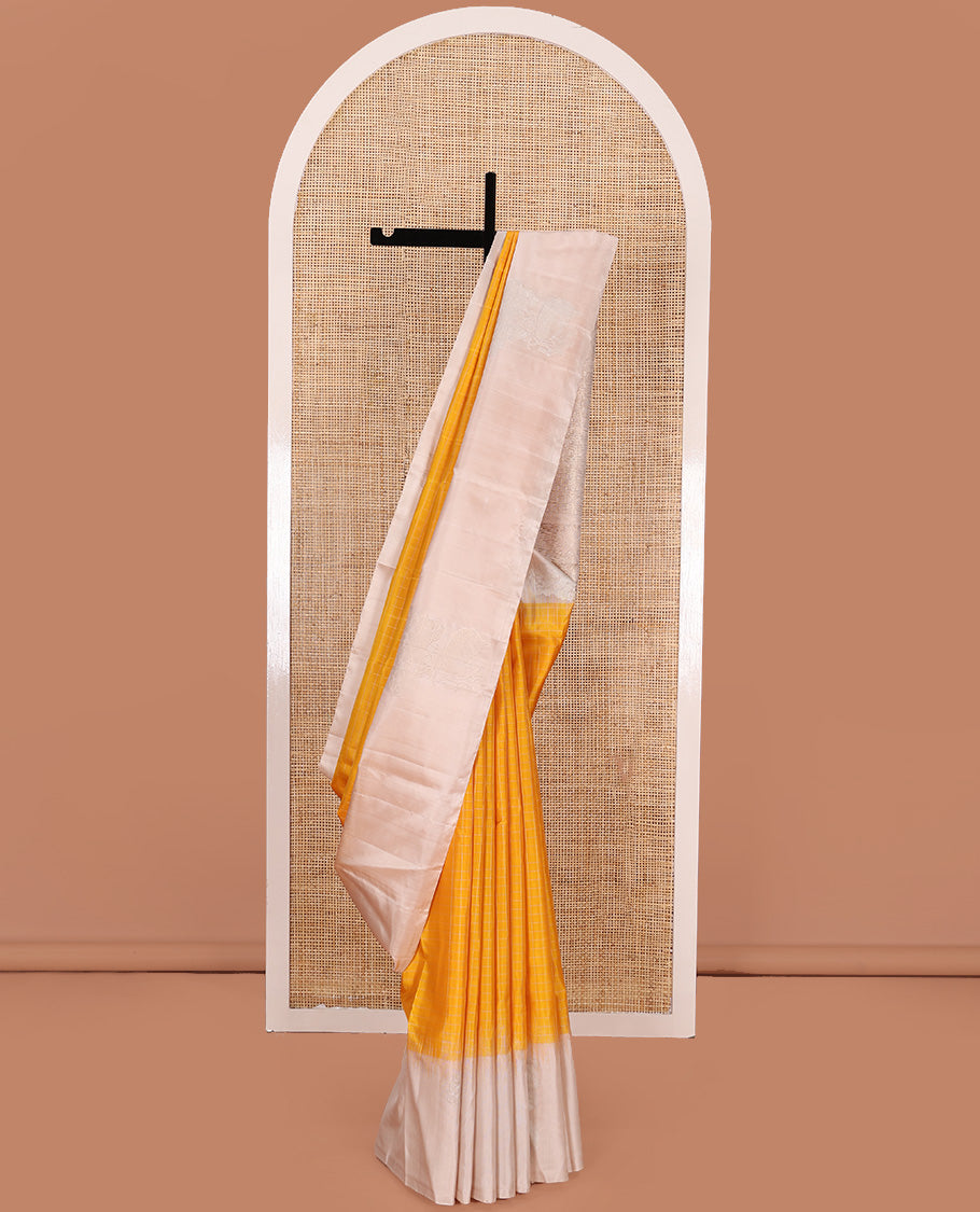Yellow checked Kanchipuram silk saree, contrast border of zari buttas, and pallu of geometric patterns