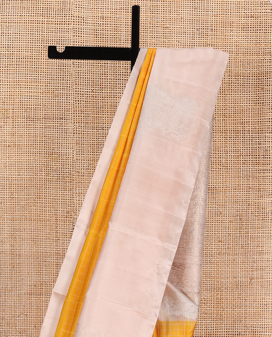 Yellow checked Kanchipuram silk saree, contrast border of zari buttas, and pallu of geometric patterns