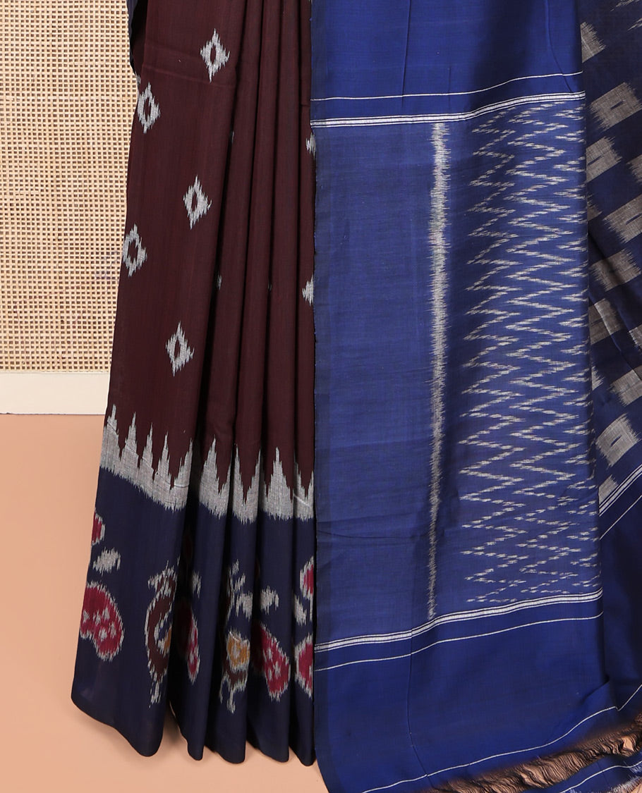 Brown Ikkat Cotton Saree, Decked Up with Ikkat Buttas All Over Its Body, Complemented by a Contrast Ikkat-Style Border of Peacock Buttas, Chevron Striped Pallu, and Paired with a Contrast Blouse