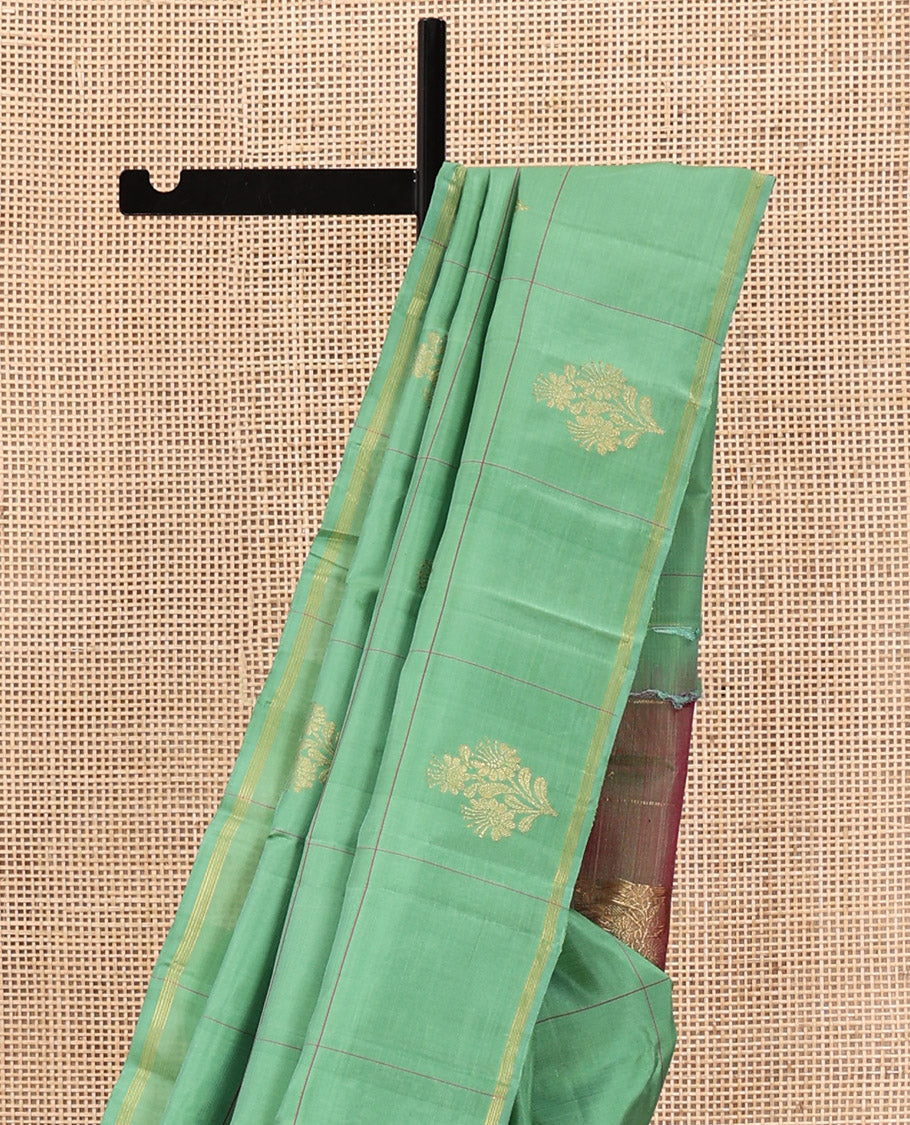 Green Kanchipuram Silk Saree, Beautifully Woven with Floral Butta Enclosed, Checked All Over Its Body, Subtle Zari Piping Border, Captivating Pallu of Intricate Designs, and Paired with a Contrast Blouse