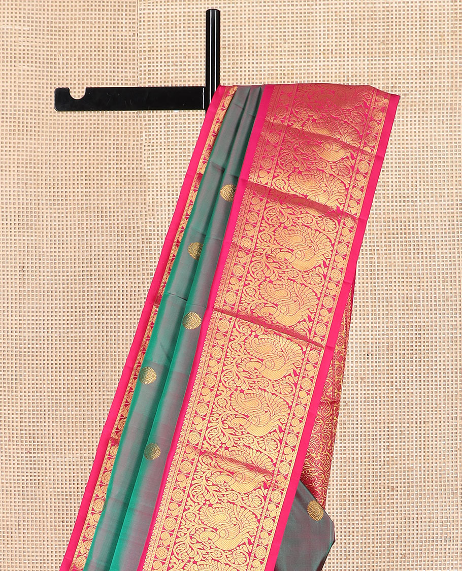 Green dual-tone chakram buttas Kanchipuram silk saree, contrast border of mayil chakram designs, and pallu of chakram buttas