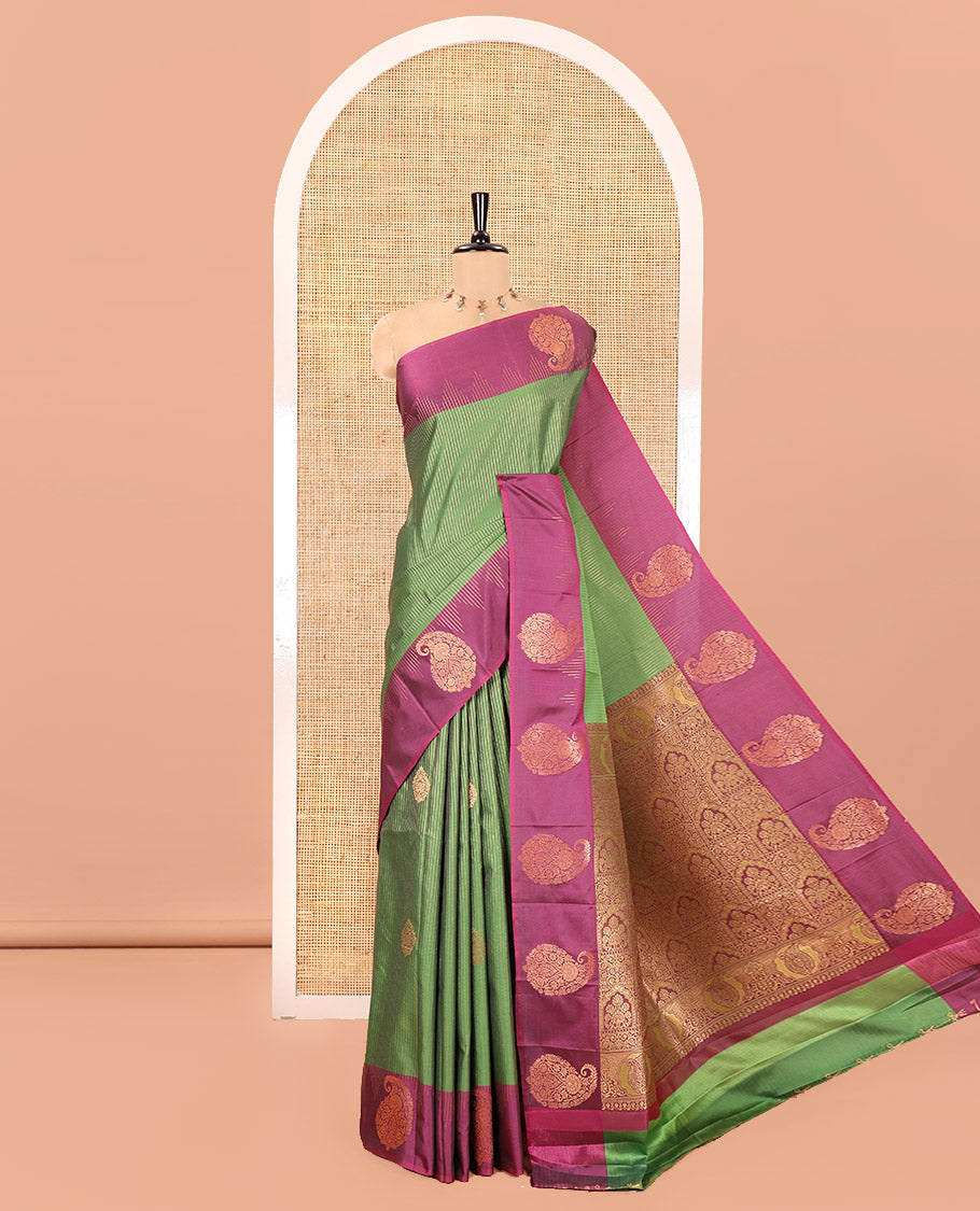 Forest Green Kanchi Soft Silk Saree, Majestically Detailed with Vaira Oosi, and Zari Buttas All Over Its Body, Complemented by Contrast Border of Paisleys, an Intricately Designed Pallu, and Paired with a Contrast Blouse