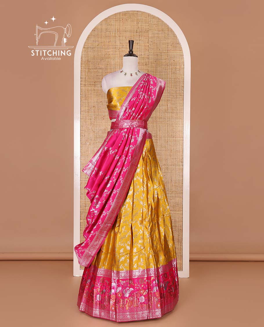 Haldi yellow taffeta silk half saree, floral jaal jacquard skirt, contrast rani zari meenakari style bird border, matching blouse, and floral jaal dhavani