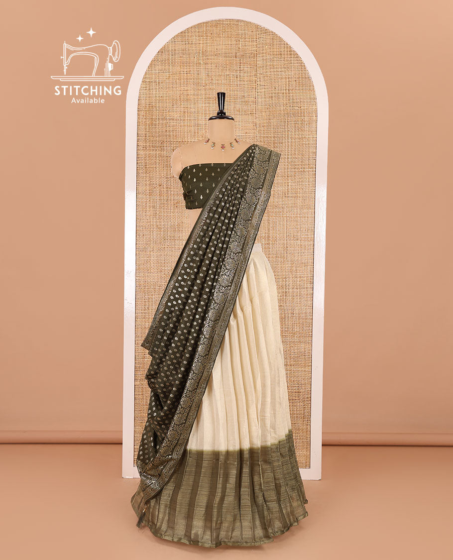 Cream-olive green Vichitra half-saree, plain and contrast bordered skirt, contrast leaf buttas blouse, dhavani of buttas and floral creeper designs