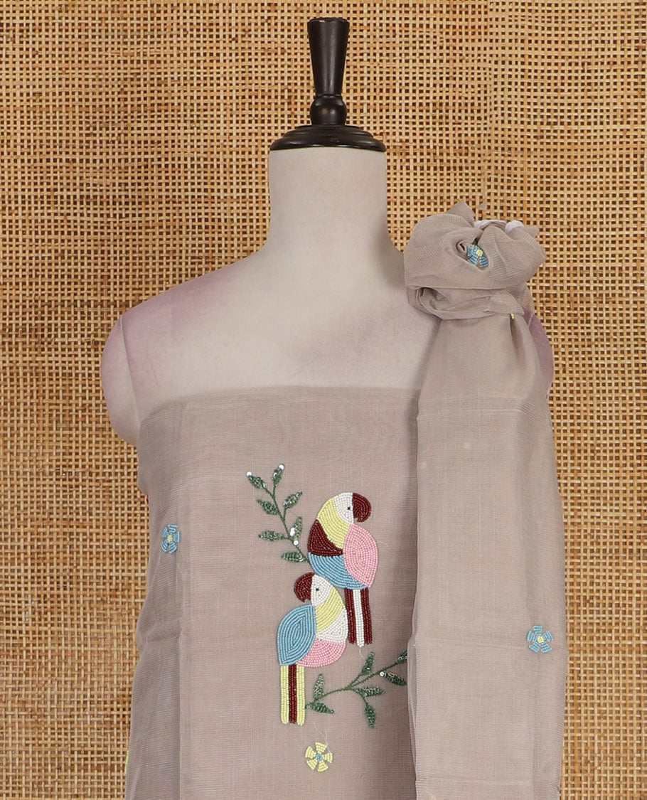 Light grey net kota material chudidar set, macaw parrot, and flower motifs, multi-color sugar bead embroidered top, plain santoon bottom, and sugar bead embroidered dupatta