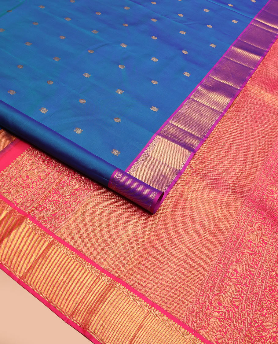 Blue mayil chakram buttas Kanchipuram silk saree, contrast border of thilakam mokku, banaras, muthu, and zari stripes, and mayil kann pallu