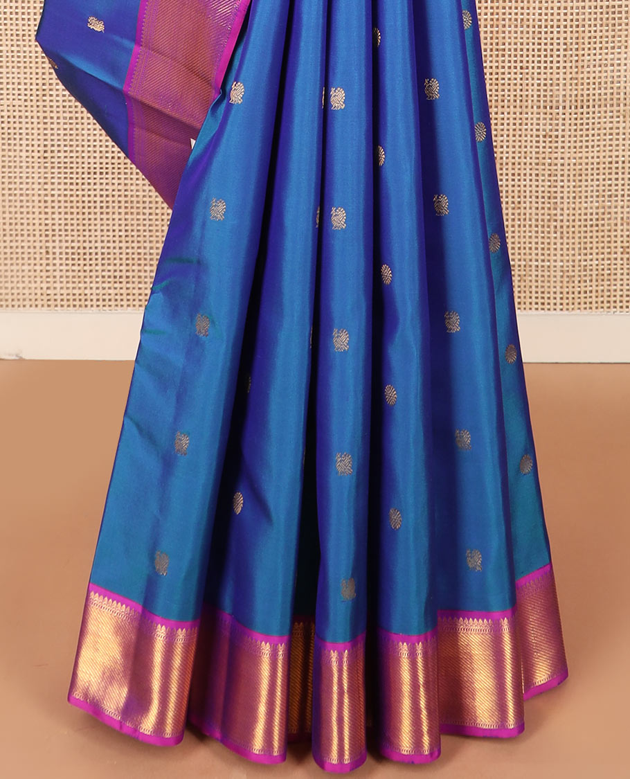 Blue mayil chakram buttas Kanchipuram silk saree, contrast border of thilakam mokku, banaras, muthu, and zari stripes, and mayil kann pallu