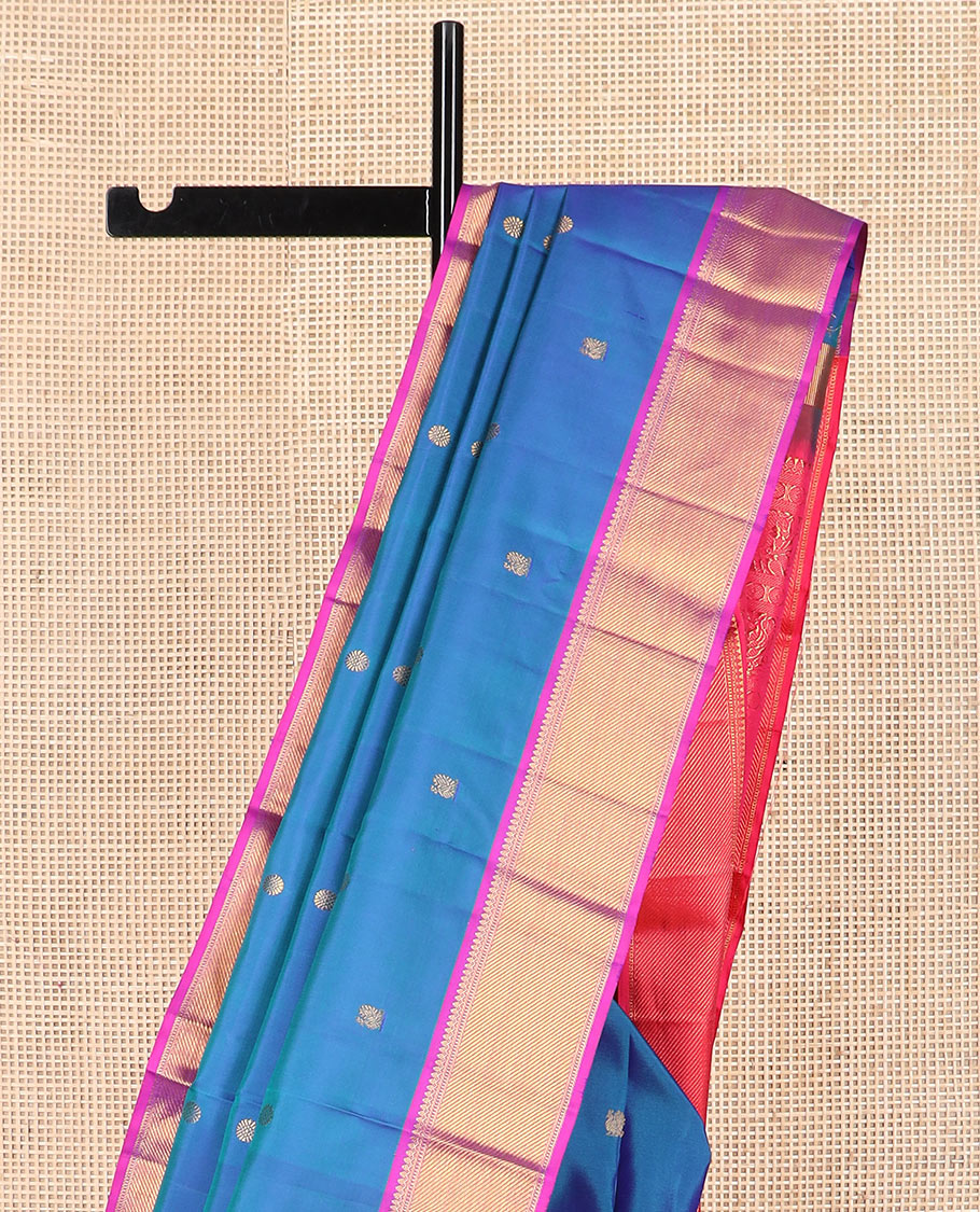Blue mayil chakram buttas Kanchipuram silk saree, contrast border of thilakam mokku, banaras, muthu, and zari stripes, and mayil kann pallu