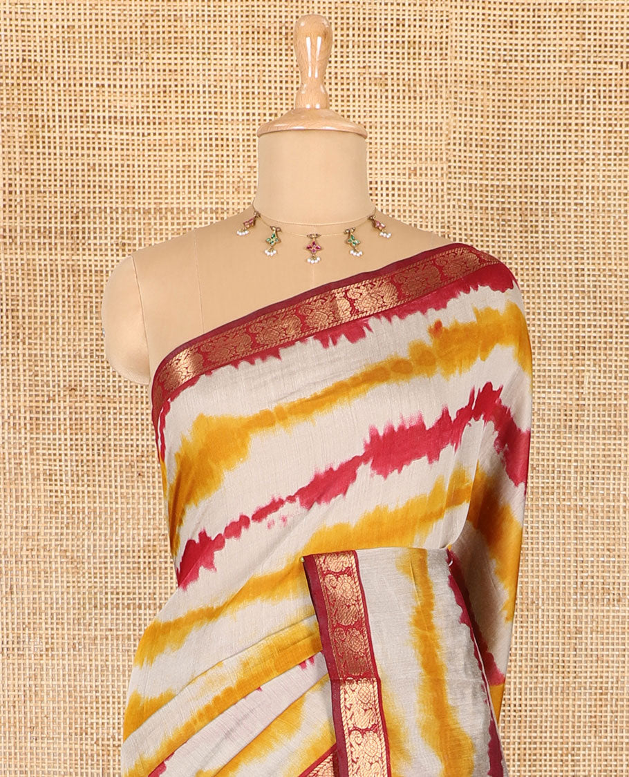 Yellow shibori printed muslin cotton saree, contrast peacock zari border, village scenery printed pallu, and a contrast polka dotted zari border blouse
