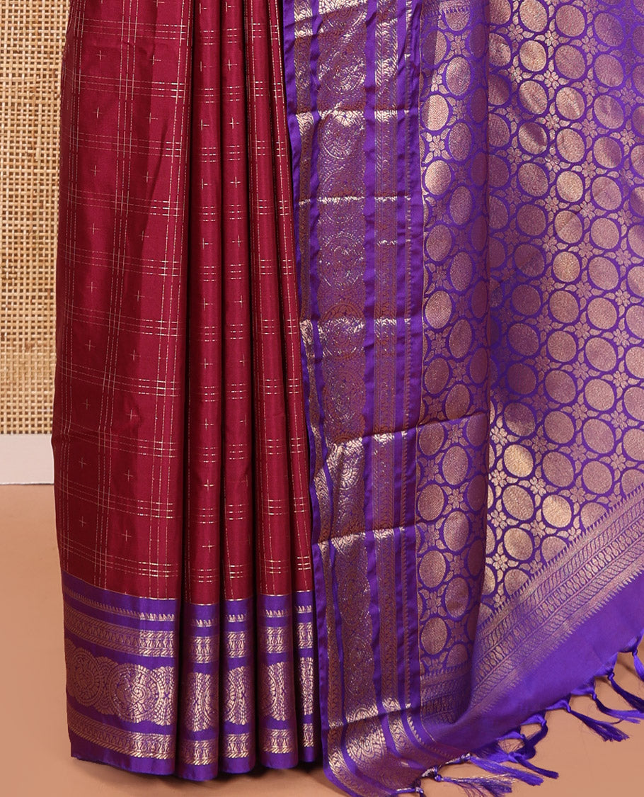 Maroon Kanchipuram Budget Silk Saree, Ornamented with Plus-Sized Butta Enclosed Checks All Over Its Body, Complemented by a Contrast Traditional Zari Border of Round Peacock Designs, Pallu Steeped with Circle Motifs, and Paired with a Contrast Blouse