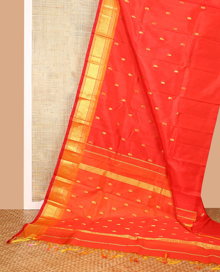 Orange Kanchipuram Silk Saree, Bedecked with Zari Buttas All Over Its Body, Complemented by a Contrast One-Sided Border of Panner Sombu, Banaras, and Mayil Kann Designs, Pallu of Zari Designs, and Comes Without a Blouse