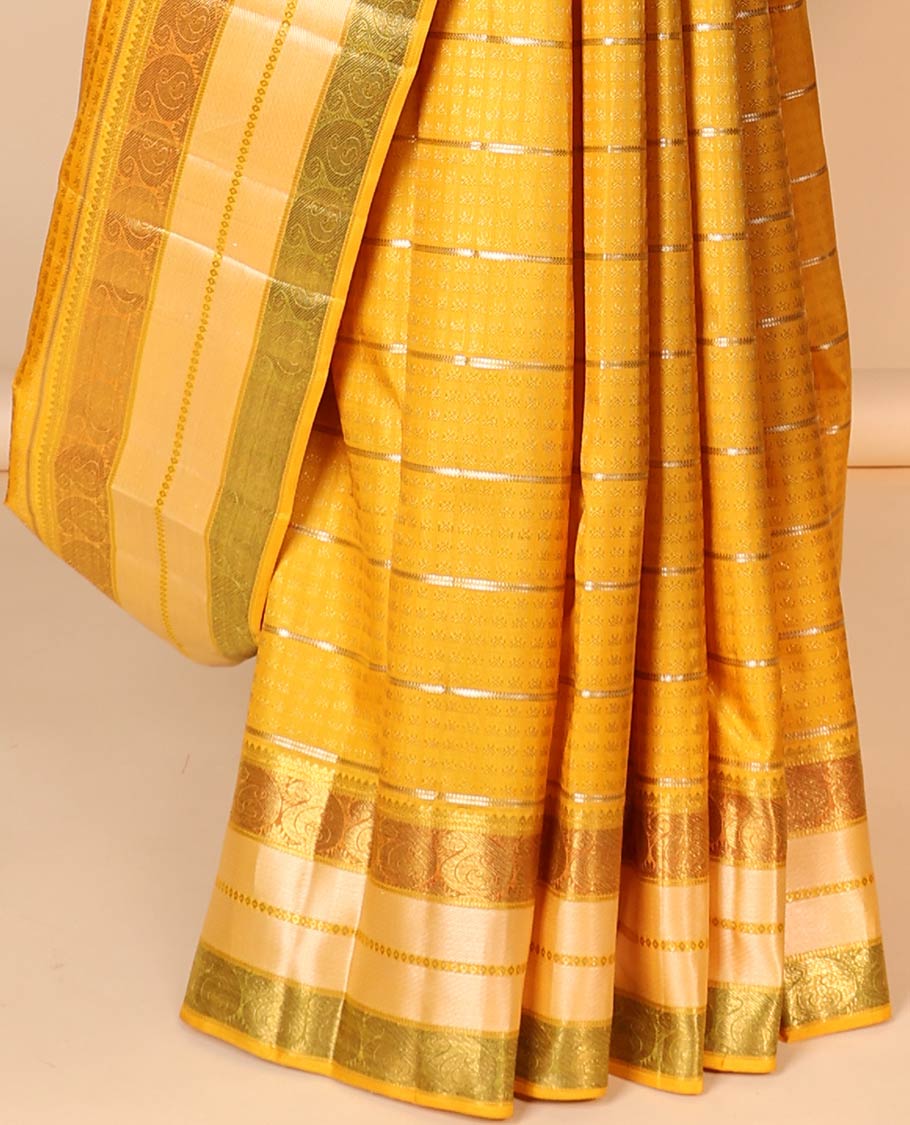 Yellow embossed silk saree with sparkling zari stripes, intricate pallu & zari border of thilakam mokku & manga designs