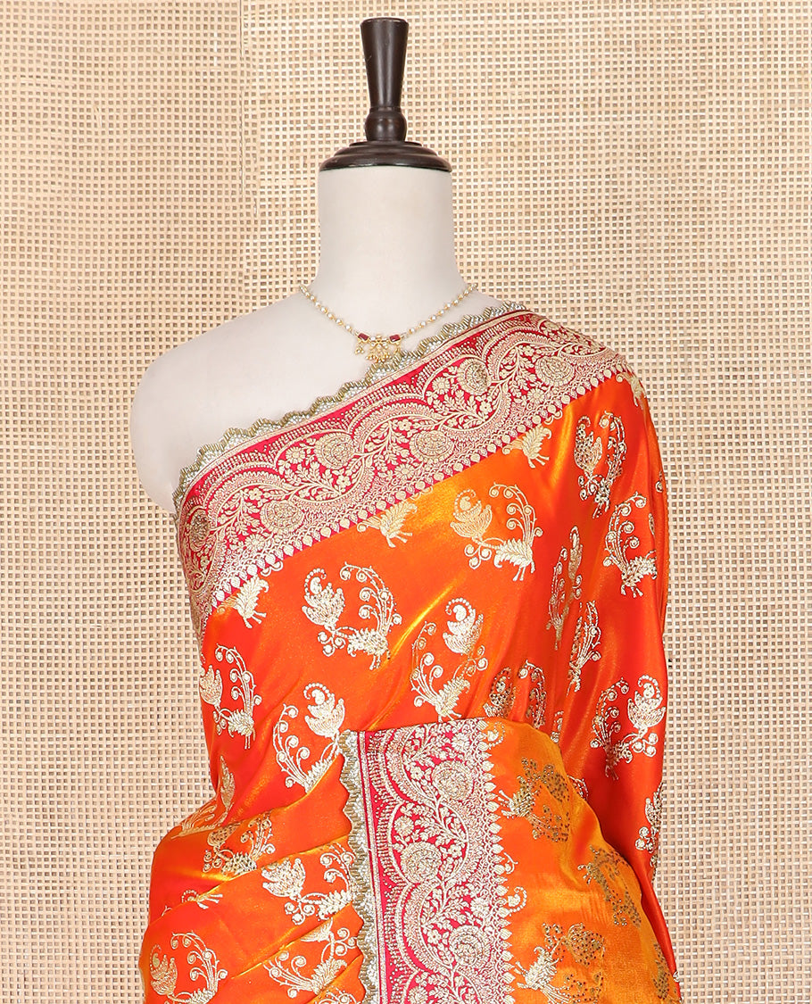 Orange Art Vastrakala Silk Saree Bedecked with Zari Buttas with Stone Work All Over Its Body, Complemented by a Contrast Floral Scallop Design Zari Stone Work Border, Mughal-Design Pallu Detailed in Zari and Stone Work, and Paired with a Contrast Blouse