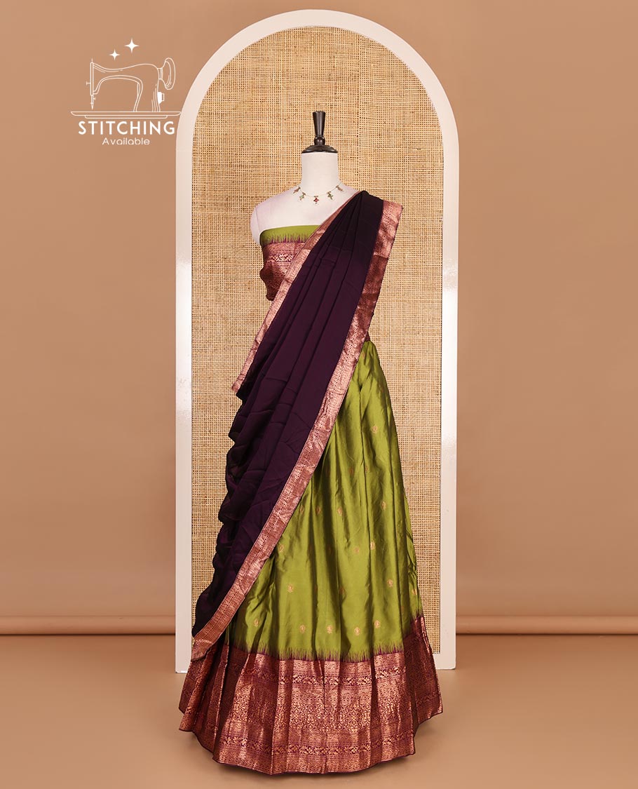 Leaf green taffeta silk half saree, zari buttas with contrast purple traditional zari border, matching zari blouse, and contrast plain zari border dhavani