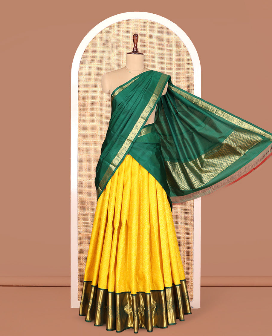 Yellow Pure Silk Half-Saree, Sparsely Woven with Floral Jacquard All Over Its Skirt, Complemented by a Contrast Korvai Border of Thilakam Mokku, Paisa, and Diamond Designs, Paired with a Contrast Blouse, and Comes with a Jaal Design Dhavani