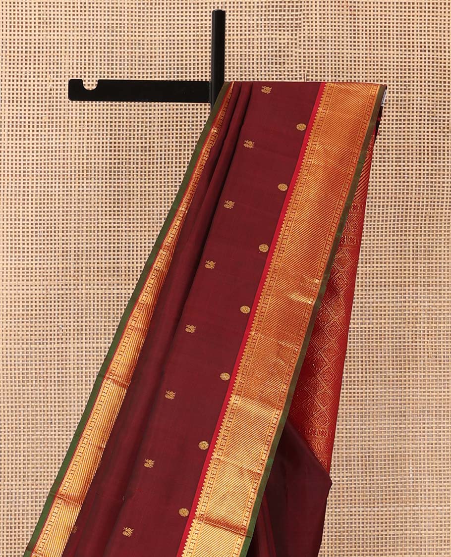 Maroon mayil poun buttas Kanchipuram silk saree, contrast border of rekku, banaras, cross kamalam, and zari stripes, and zari rich jaal pallu