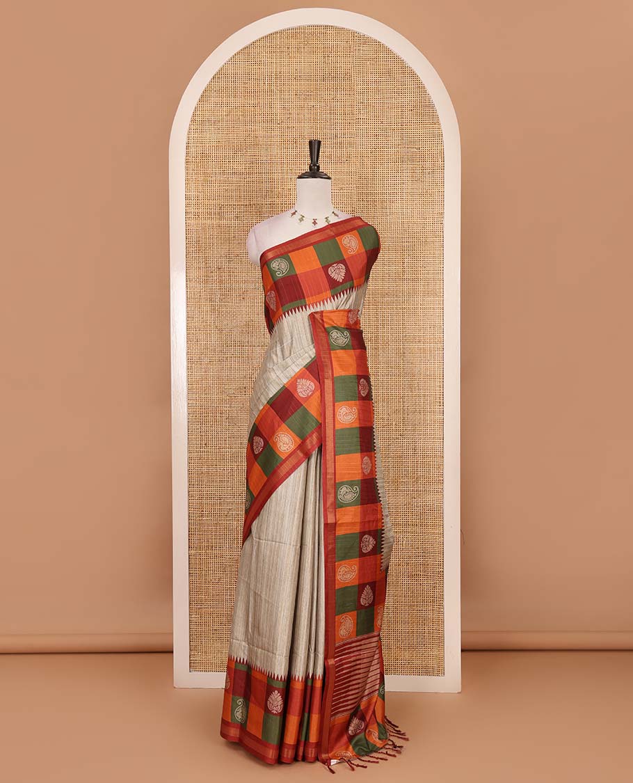 Chikku- orange plain kathan silk saree, contrast buttas enclosed multi-color checked blocks border, temple pallu, and contrast blouse of checks, and buttas