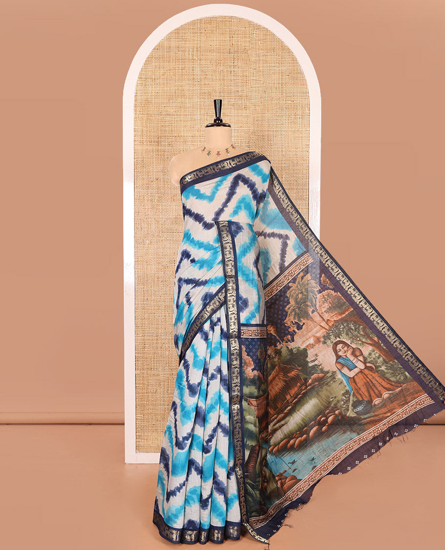 Blue Muslin Cotton Saree Adorned with Zig-Zag Shibori Patterns Prints, Complemented by a Contrast Border of Deer Motifs in Zari, Pallu Decked Up with Scenery Print, and Paired with a Contrast Polka Dots Printed Blouse