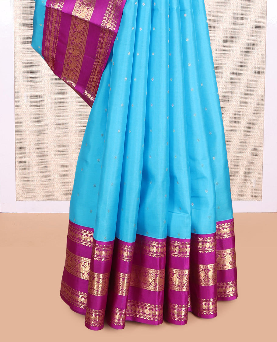Blue Vasundhara Silk Saree Gracefully Embellished with Zari Buttas, Complemented by a Varisai Pettu Border Featuring Rekku, Muthu, Banaras, Rudraksham, and Mayil Designs, Majestically Woven with a Zari-Designed Pallu, and Paired with a Contrast Blouse