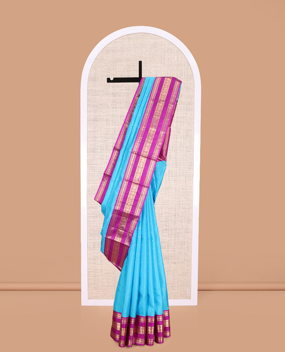 Blue Vasundhara Silk Saree Gracefully Embellished with Zari Buttas, Complemented by a Varisai Pettu Border Featuring Rekku, Muthu, Banaras, Rudraksham, and Mayil Designs, Majestically Woven with a Zari-Designed Pallu, and Paired with a Contrast Blouse