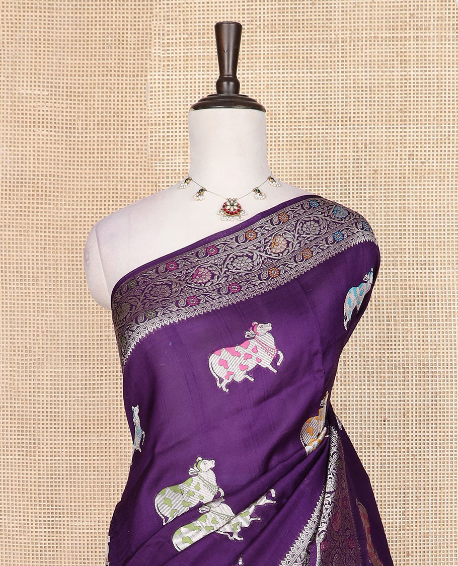 Purple Matka silk saree features Pichwai cow motifs, floral creeper design border, and intricate pallu