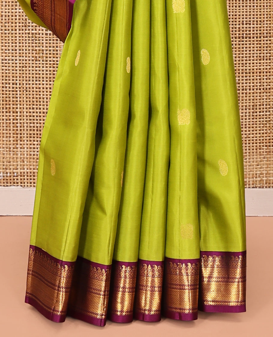 Green Vasundhara Silk Saree, Prettified with Zari Buttas All Over Its Body, Complemented by a Contrast Border of Thilakam, Manga, Muthu, Ara Bogudi, and Mayil Kann Designs, Grand Pallu, and Paired with a Contrast Blouse