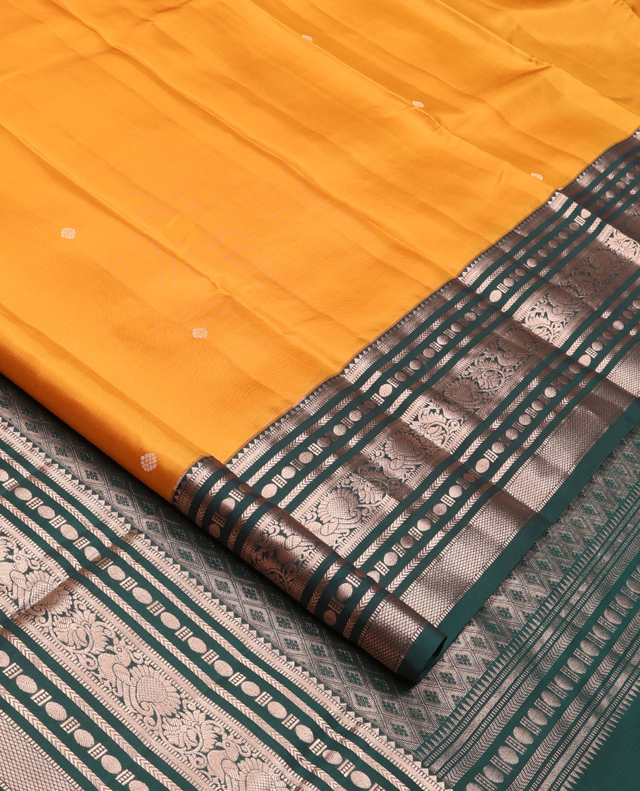 Yellow Vasundhara Silk Saree, Prettified with Zari Buttas All Over Its Body, Complemented by Contrast Border of Rekku, Muthu, Kathir, Poun, Mayil, and Mayil Kann Designs, Grand Jaal Pallu and Paired with a Contrast Blouse