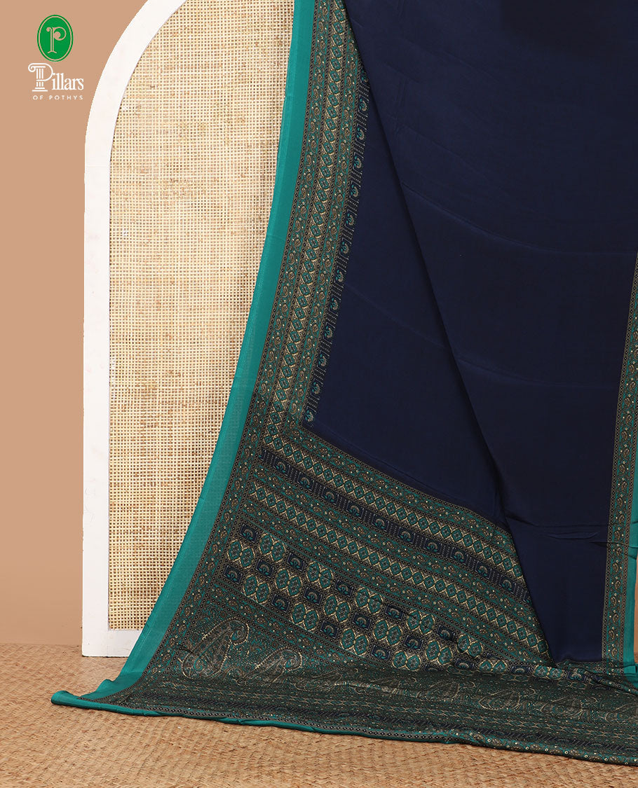 Blue plain crepe saree adorned with contrast printed border featuring geometric motifs, floral and paisley vine design