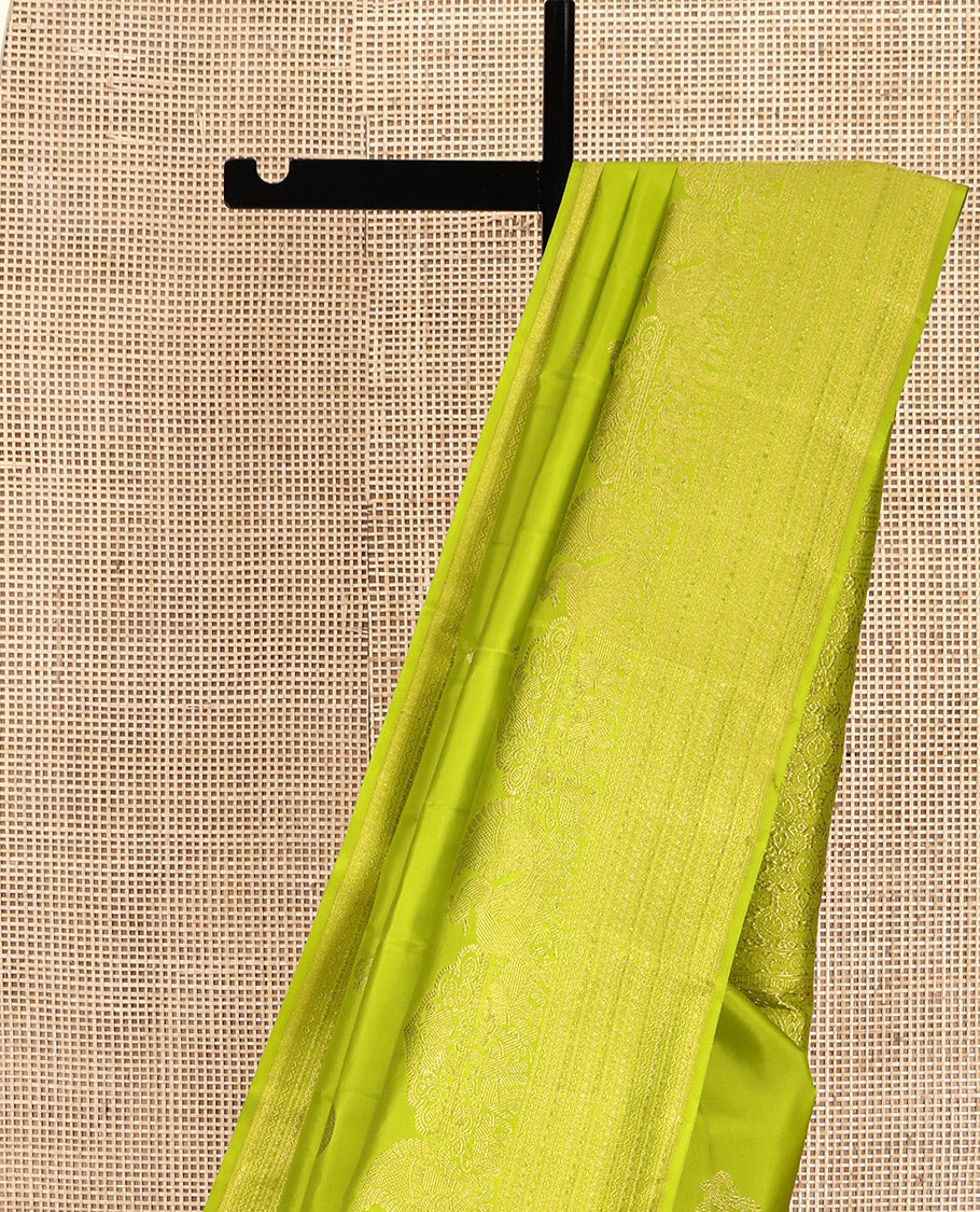 Parrot Green Kanchipuram Silk Saree, Gleamed Up with Zari Buttas All Over Its Body, Highlighted by a Zari Border of Mayil, Yaanai, and Neli Designs, Intricately Designed Pallu, and Paired with a Matching Blouse