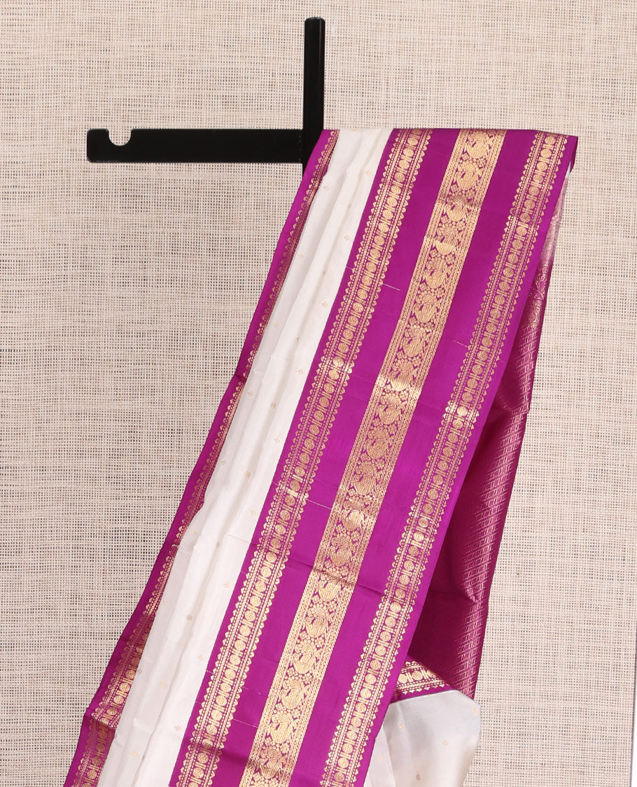White Vasundhara Silk Saree Elegantly Embellished with Zari Buttas, Complemented by a Varisai Pettu Border Featuring Rekku, Muthu, Banaras, Rudraksham, and Mayil Designs, Majestically Woven with a Zari-Designed Pallu, and Paired with a Contrast Blouse