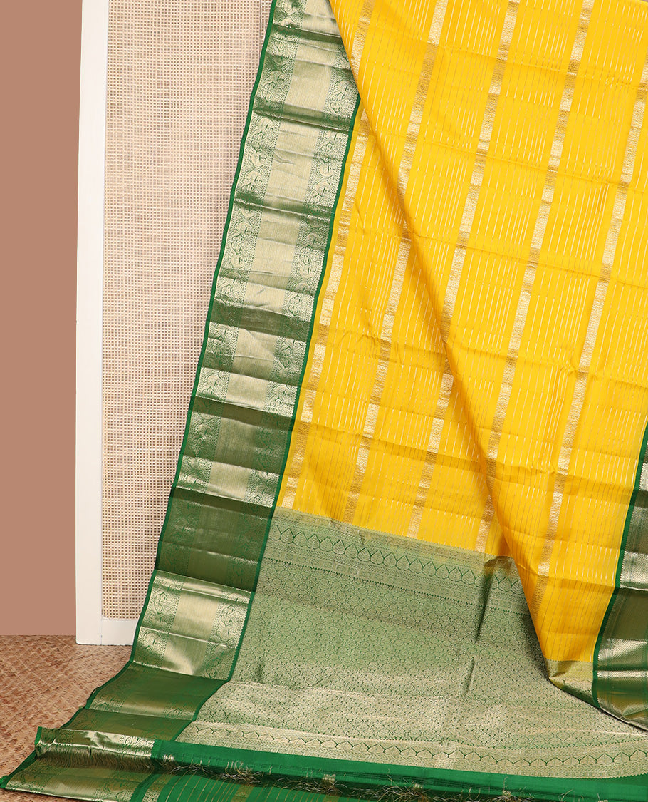 Yellow zari design silk saree, contrast border of reeku, lavangam, and kili designs, and ogee patterned pallu