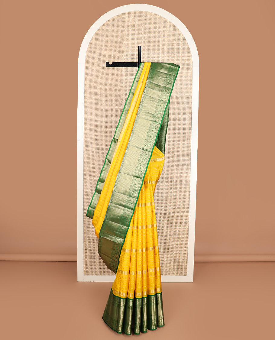 Yellow zari design silk saree, contrast border of reeku, lavangam, and kili designs, and ogee patterned pallu