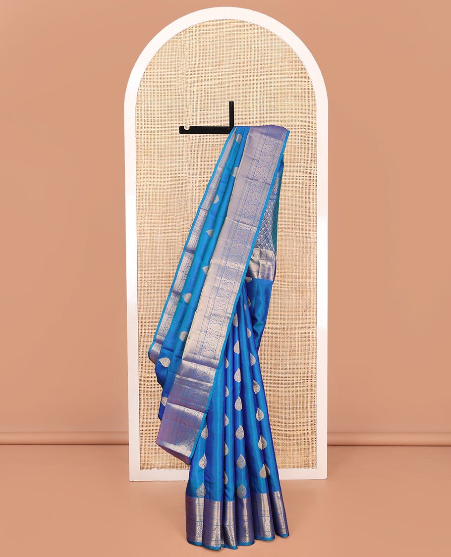 Blue Vasundhara Silk Saree, Mesmerized with Zari Buttas on Its Body, Highlighted by a Zari Border of Manga Mokku, Muthu, and Arumbu Manga Designs, Pallu Steeped with Leaf Designs, and Paired with a Matching Blouse