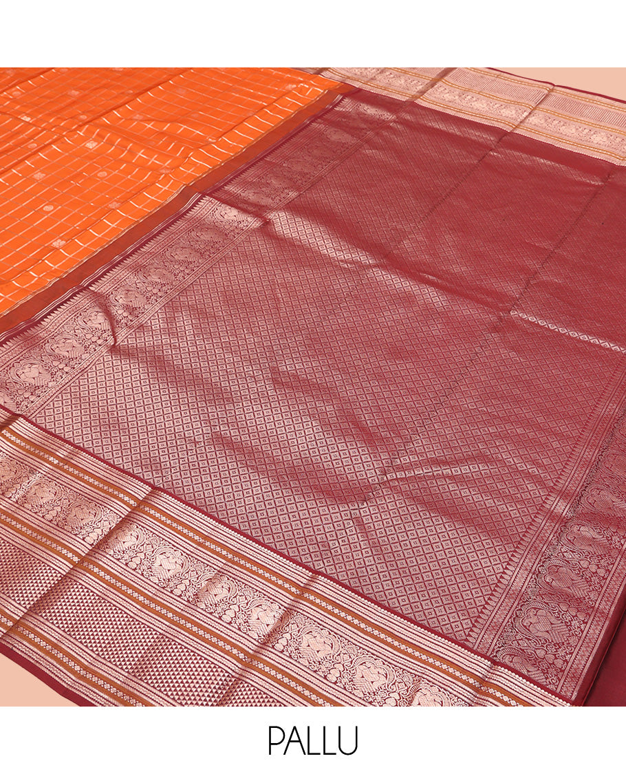 Orange Vasundhara Silk Saree, Meticulously Crafted with Zari Butta Enclosed Checks, Complemented by Contrast Border of Thilakam Mokku, Rettai Neli, Iruthalai Pakshi, and Ara Maadam Designs, Grand Jaal Pallu and Paired with a Contrast Blouse