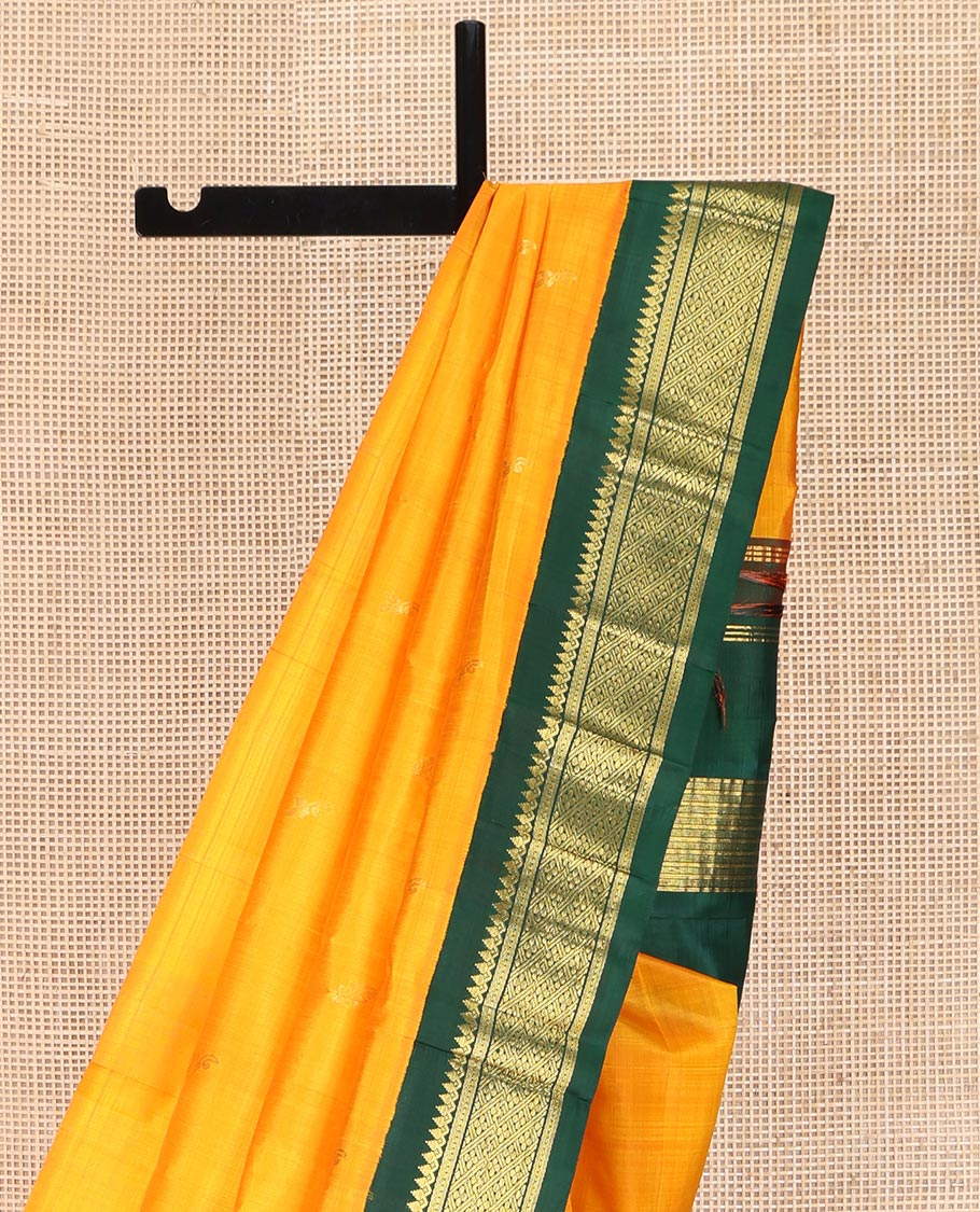 Yellow Kanchipuram Silk Saree, Sparsely Sparkled with Zari Buttas on Its Body, Complemented by a Contrast One-Sided Korvai Border of Thilakam Mokku, Banaras, Muthu, and Kamalam Designs, Pallu Features Zari Designs, and Comes Without a Blouse