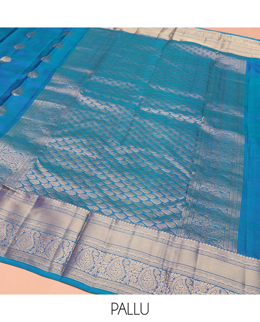 Blue Vasundhara Silk Saree, Mesmerized with Zari Buttas on Its Body, Highlighted by a Zari Border of Manga Mokku, Muthu, and Arumbu Manga Designs, Pallu Steeped with Leaf Designs, and Paired with a Matching Blouse