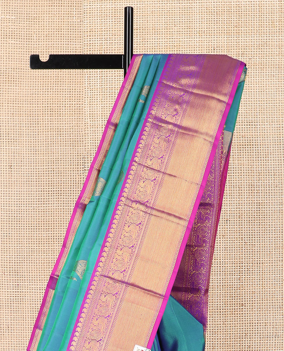 Blue arumbu manga buttas Kanchipuram silk saree, contrast border of manga mokku, muthu, kathir, and mayil designs, and vanki design pallu