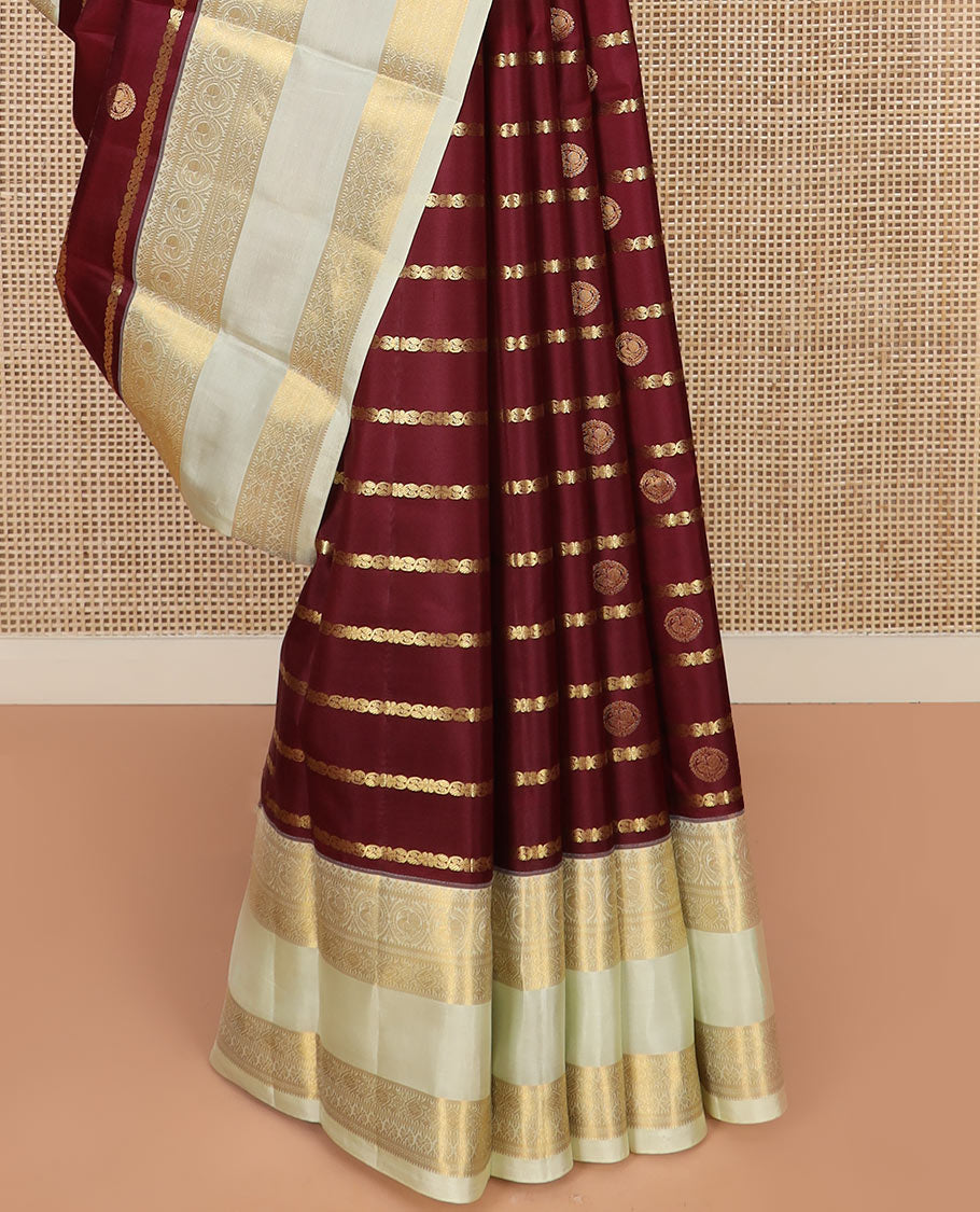 Maroon Vasundhara Silk Saree Richly Detailed with Zari Buttas and Zari Designs, Complemented by a Contrast Rettai Pettu Border of Round Mayil Designs, Subtly Designed Pallu of Floral Jaal Designs, and a Contrast Blouse