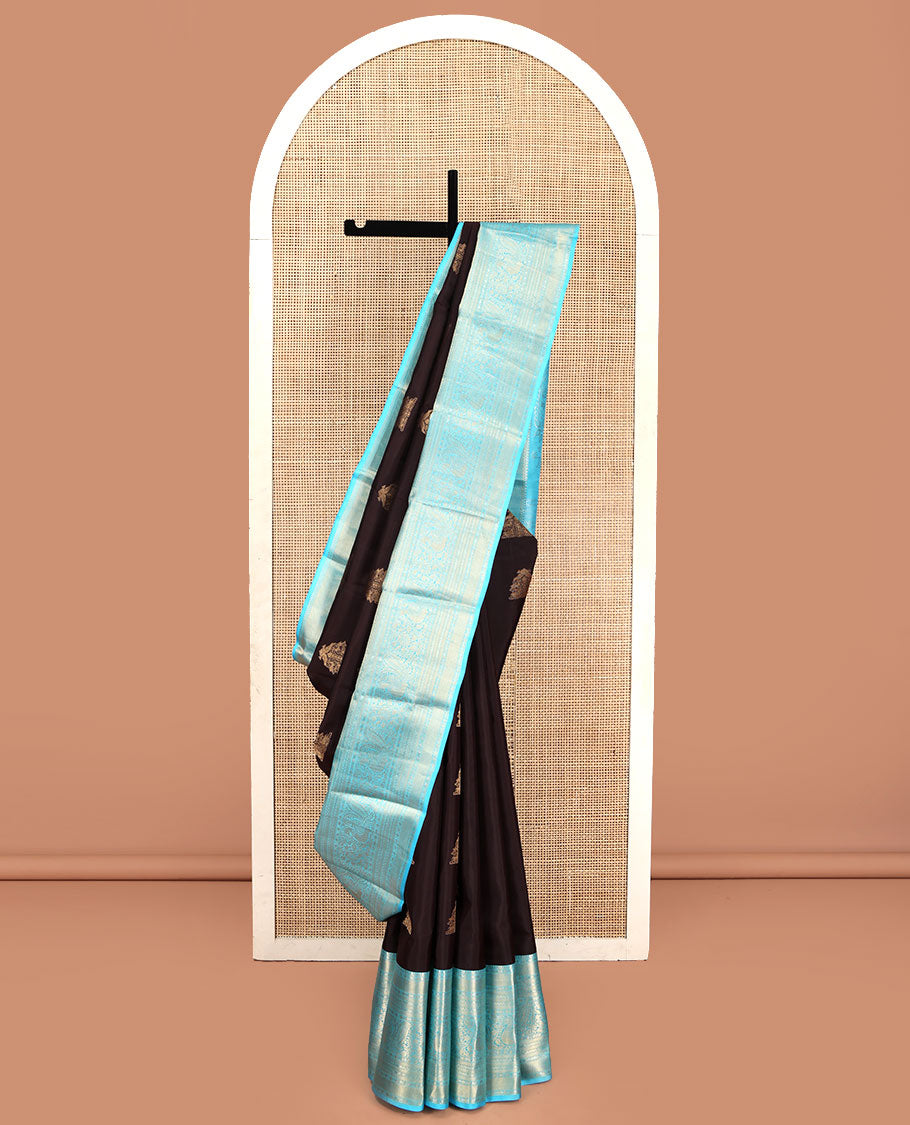 Brown Vasundhara Silk Saree, Elegantly Highlighted with Zari Buttas All Over Its Body, Complemented by Contrast Border of Salngai, Rettai Neli, Kodi Mayil, and Mayil Kann Designs, Grandly Embellished Pallu, and Paired with a Contrast Blouse