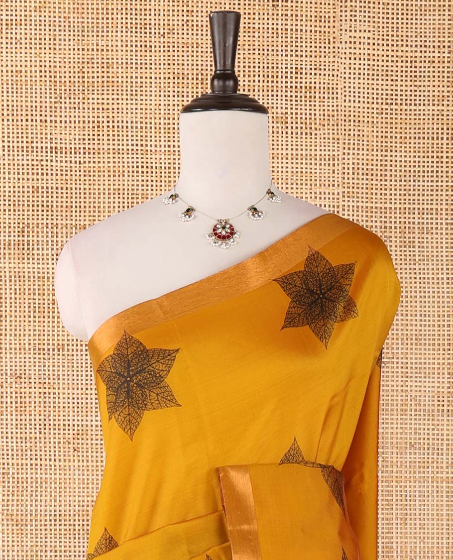 Mustard six-petal-like leaf motifs printed micro-silk saree, copper zari border, contrast intricate pallu & plain red blouse